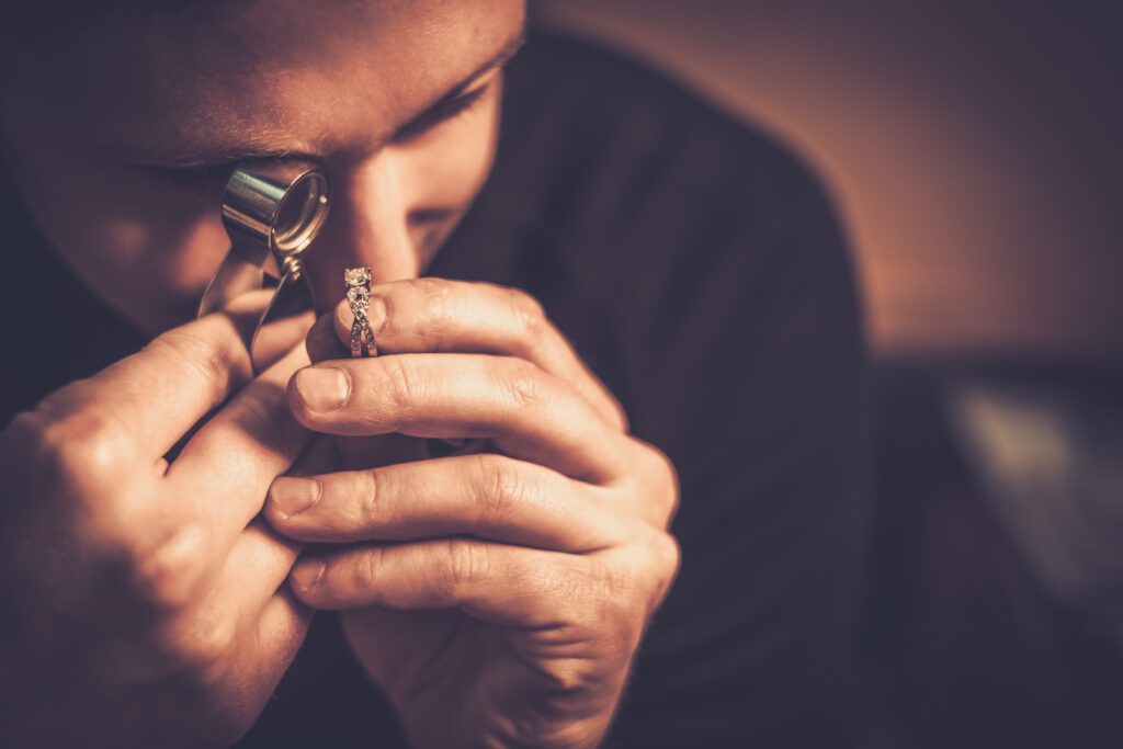 Prüfung eines Diamantrings mit der Juwelierslupe