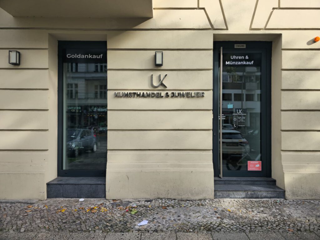 Ladengeschäft von Uhland Kunsthandel & Juwelier in der Uhlandstraße 162 in Berlin: Schaufenster mit der Aufschrift „Goldankauf“, Schriftzug „Kunsthandel & Juwelier“ und Eingangstür